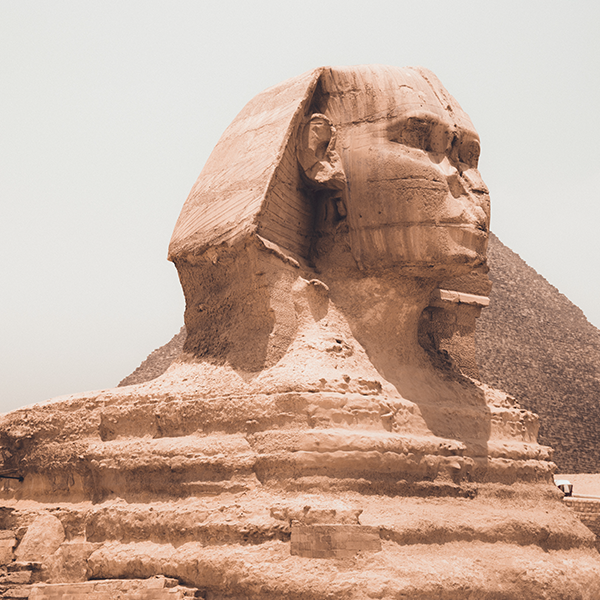 The Great Sphinx of Giza, an ancient limestone statue with the body of a lion and the head of a pharaoh, situated in the desert.
