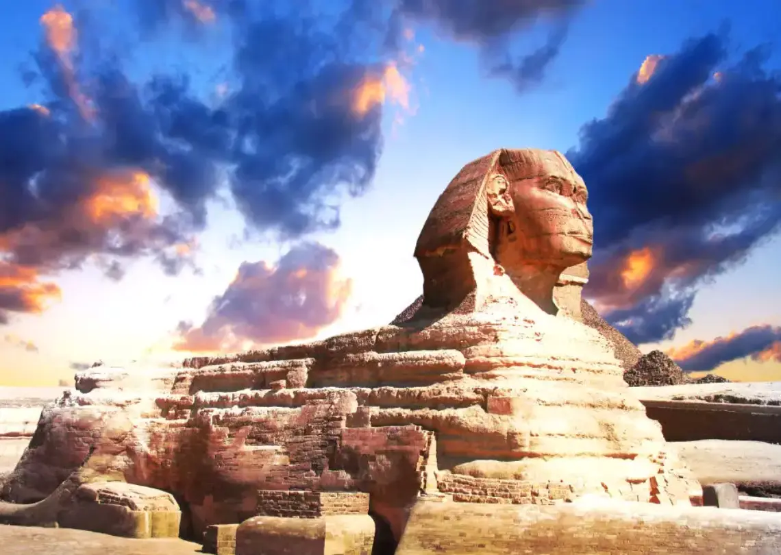 The Great Sphinx of Giza, an ancient limestone statue with the body of a lion and the head of a pharaoh, situated in the desert.